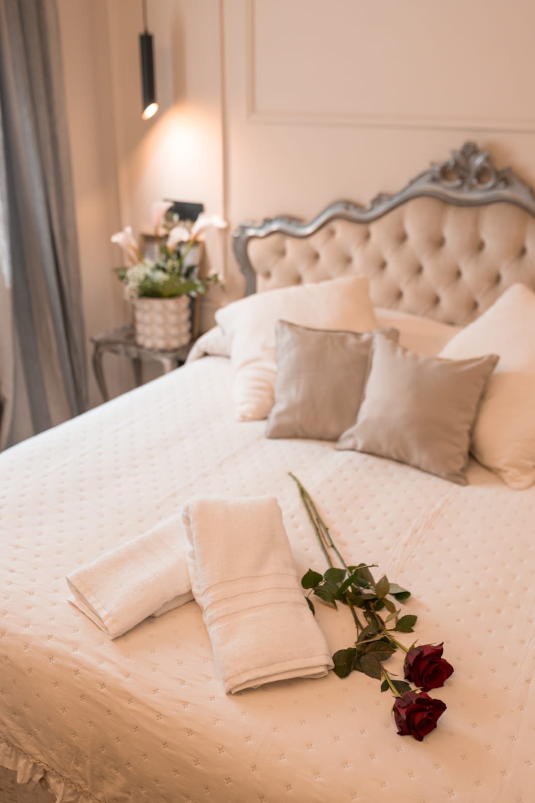 Letto matrimoniale con testiera capitonné e rose rosse sul copriletto, Luxury Suite a Nemi